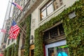 Low Angle View of Macy`s Store Department Facade. Decorated with Christmas Green Garland and Lights. American Flags Waving Proudly