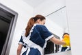 Low angle view on maid cleaning mirror Royalty Free Stock Photo