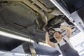 Low angle view of male automobile mechanic repairing car in repair shop Royalty Free Stock Photo