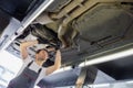 Low angle view of male automobile mechanic repairing car in repair shop Royalty Free Stock Photo