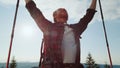 Tourist standing on top of mountain. Happy guy with ski poles raising hands Royalty Free Stock Photo