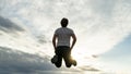 Low angle view of a man jumping up high in the air under a dramatic sky Royalty Free Stock Photo