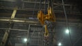 Low angle view of manual worker operating crane lifting sheet metal in industry. Crane in the factory lifts metal sheets Royalty Free Stock Photo