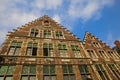 Low angle view on medieval brick stone house facade with typical belgian stepped gabled roof against blue sky with clouds -  Ghent Royalty Free Stock Photo