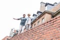 Low angle view of middle-aged couple with arms outstretched walking on brick wall against clear sky Royalty Free Stock Photo