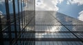 Modern Glass Skyscraper Reflecting Clouds and Sunlight Against Blue Sky building architecture Royalty Free Stock Photo