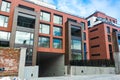 Low angle view on modern residential brick apartment building exterior with large windows. Modern Apartment Complex Under