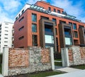 Low angle view on modern residential brick apartment building exterior with large windows. Modern Apartment Complex Under