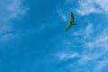 Low angle view of motorized hang-gliding against blue sky with white clouds. Royalty Free Stock Photo