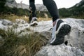 Low angle view of female hiking shoes stepping on rocky mountain trail Royalty Free Stock Photo