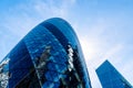 Low angle view of office buildings in the City of London against blue sky. Gherkin Royalty Free Stock Photo