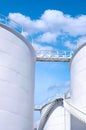 The old white fuel tanks with spiral staircase against blue sky background