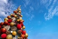 Low Angle View. Outdoor Giant Christmas tree with a cloudy sky background. Ant view image of Christmas tree