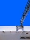 Overhead gas metal pipelines system on white building against blue clear sky Royalty Free Stock Photo