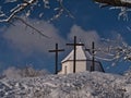 View of peak of KornbÃÂ¼hl hill, Swabian Alb, Germany in winter with chapel Salmendinger Kapelle and three Christian crosses. Royalty Free Stock Photo