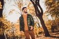 Low angle view photo of attractive positive guy go outdoors autumn park look wear season outercoat Royalty Free Stock Photo