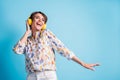 Low angle view photo of happy joyful young woman listen good music headphones dance isolated on blue color background Royalty Free Stock Photo