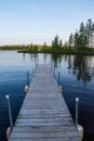 Low angle view of pier jutting out into the Chippewa Flowage in front of a wooded island in the Northwoods forest of Hayward Royalty Free Stock Photo