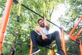 Powerful young man doing one-arm pull-ups while hanging on a bar in park Royalty Free Stock Photo