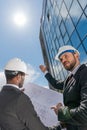 Low angle view of professional architects in hardhats working