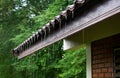 Low angle view of rain water flowing down from the eaves of a house Royalty Free Stock Photo