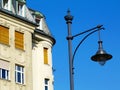 low angle view of retro style lamppost head. closeup detail. stucco building facade behind. blue sky