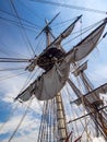 Old Tall Ship Sail, Mast, and Riggings Against Blue Sky