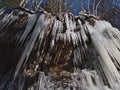 Rocky overhang on a steep slope with big frozen icicles hanging down on cold winter day at Todtnauer WasserfÃÂ¤lle near Todtnau.