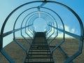 Low angle view of fire escape (safety cage) ladder on a brick wall against blue sky with clouds Royalty Free Stock Photo