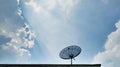 Low Angle View of Satellite Receiver Dish on the Roof Against Blue Cloudy Sky Royalty Free Stock Photo