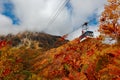 Low angle view of a scenic cable car flying over the colorful autumn valley of Tateyama Kurobe Royalty Free Stock Photo