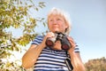 Low angle view of a senior woman with binoculars outdoors, birdwatching Royalty Free Stock Photo