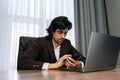 Low-angle view of serious businessman using mobile phone, scrolling and browsing through social media, during working on Royalty Free Stock Photo