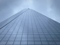 Low angle view of the Shard against cloudy sky.