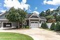 Low angle view of the side of a large gray craftsman new construction house with a landscaped yard a an open garage Royalty Free Stock Photo