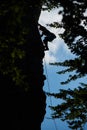 Low angle view silhouette of a girl in safety harness climbing up the rock against blue sky Royalty Free Stock Photo