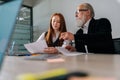 Low-angle view of skilled mature male ceo executive manager supervisor in formal wear mentoring smiling young female Royalty Free Stock Photo