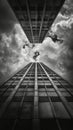 Low angle view of a skyscraper against cloudy sky in black and white Royalty Free Stock Photo