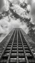 Low angle view of a skyscraper against cloudy sky in black and white Royalty Free Stock Photo