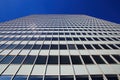 Low angle view on skyscraper facade with geometric symmetrical pattern lines against deep blue cloudless sky