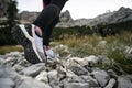 Low angle view slightly from the side of a female hiking shoes as she hikes on stones and rocks