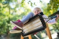 Low angle view of a small toddler girl on a swing on a playground.