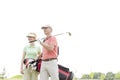 Low angle view of smiling golfers standing against clear sky Royalty Free Stock Photo