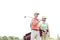 Low angle view of smiling golfers standing against clear sky Royalty Free Stock Photo