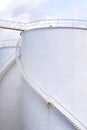 Spiral staircases on white storage fuel tanks in vertical frame