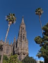 Low angle view of the steeple of Church of San Juan Bautista in the old center of town Arucas, Gran Canaria, Spain with palms. Royalty Free Stock Photo