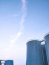 Group of storage fuel tanks inside of petroleum industrial area against blue sky in evening time Royalty Free Stock Photo