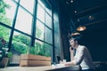 Low angle view of a successful young man, having a business conversation, at work station in a modern coworking, well dressed, s