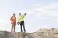 Low angle view of supervisor showing something to colleague at construction site Royalty Free Stock Photo