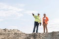 Low angle view of supervisor showing something to colleague at construction site Royalty Free Stock Photo